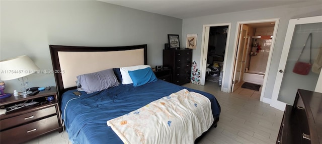 bedroom with wood finished floors and connected bathroom