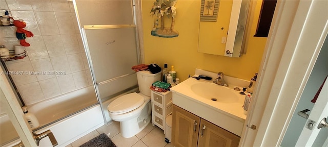 bathroom with toilet, tile patterned flooring, enclosed tub / shower combo, and vanity