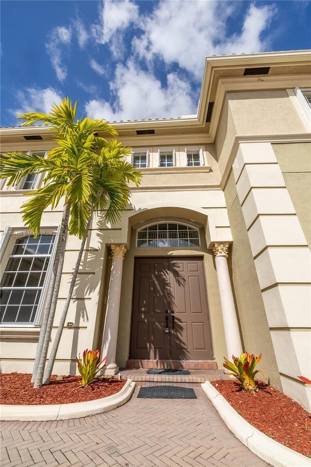 doorway to property featuring stucco siding