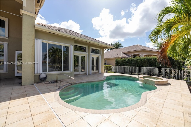 view of swimming pool with french doors, a patio area, fence, and a pool with connected hot tub