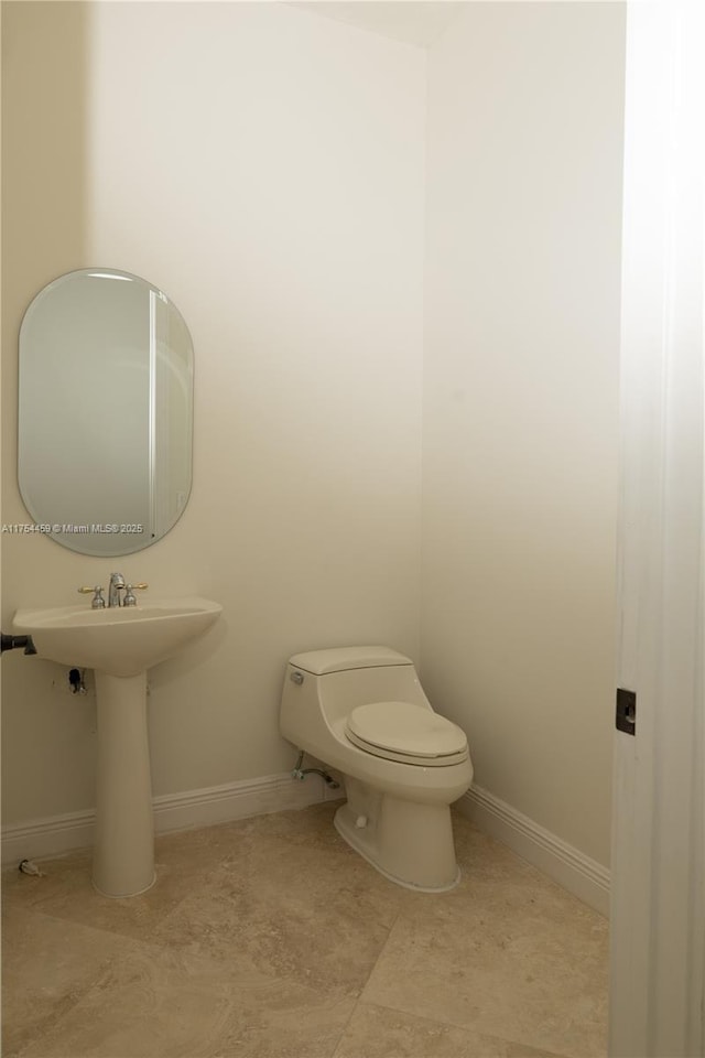 bathroom with baseboards and toilet