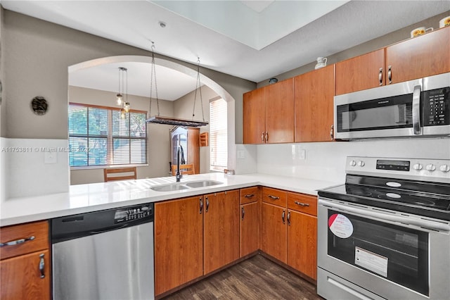 kitchen featuring appliances with stainless steel finishes, dark wood-style flooring, light countertops, and a sink