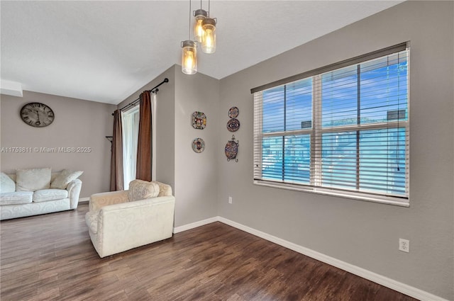 unfurnished living room featuring dark wood finished floors and baseboards