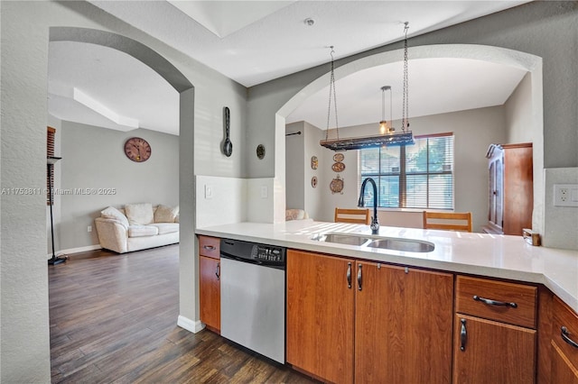 kitchen with dark wood finished floors, light countertops, brown cabinetry, a sink, and dishwasher