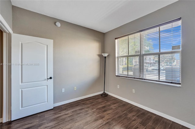 empty room with baseboards and wood finished floors