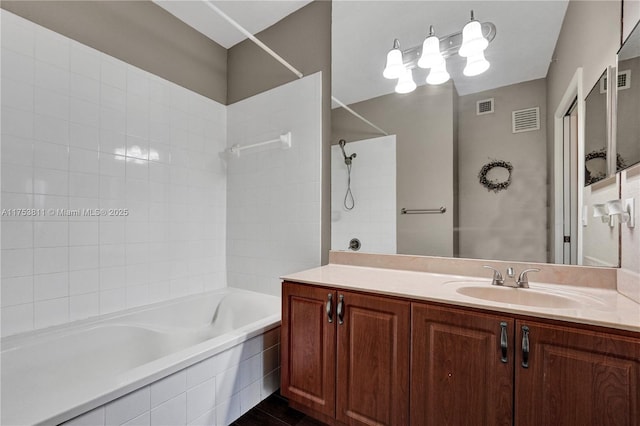 bathroom with tiled shower / bath, visible vents, and vanity