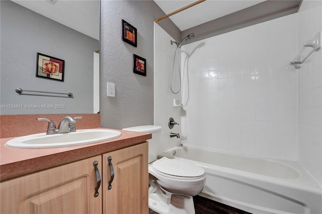 bathroom with a textured wall, vanity, toilet, and shower / bathtub combination