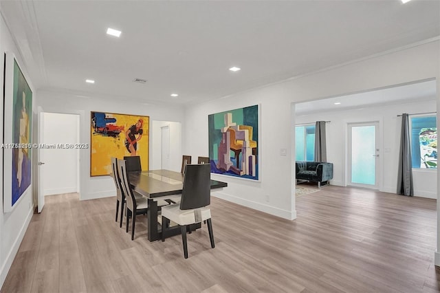 dining room featuring light wood-type flooring, baseboards, crown molding, and recessed lighting