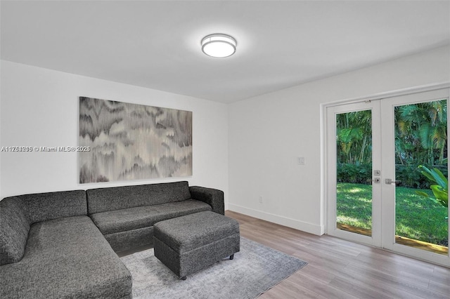 living area featuring french doors, baseboards, and wood finished floors