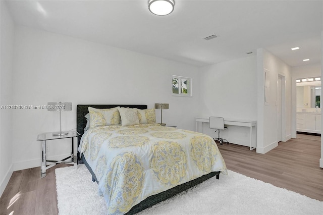 bedroom featuring visible vents, baseboards, and wood finished floors