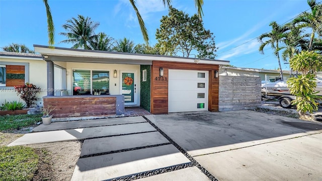 view of front facade featuring driveway, an attached garage, and stucco siding