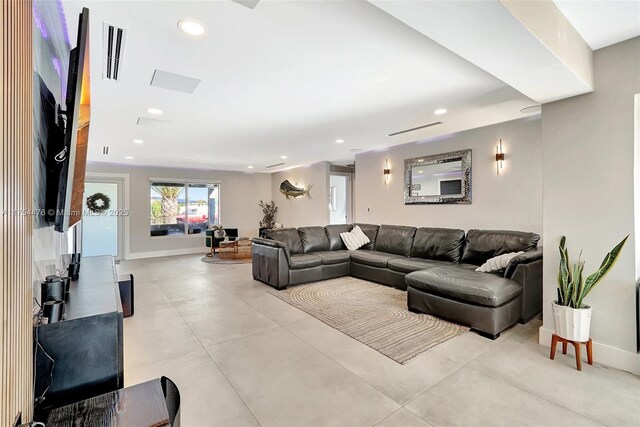 living area with baseboards, visible vents, and recessed lighting