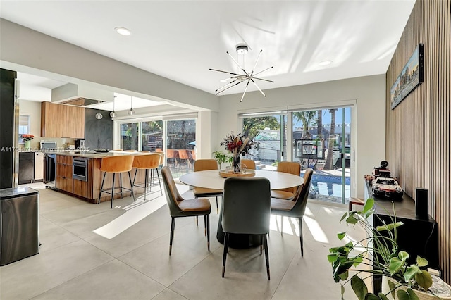 dining area featuring concrete flooring, recessed lighting, and an inviting chandelier