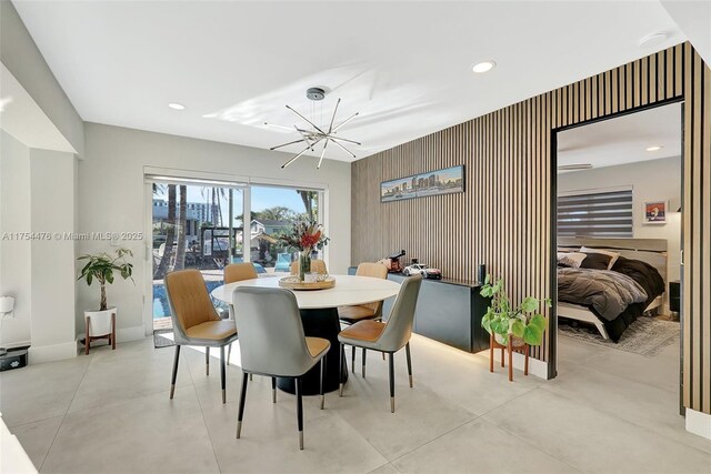 dining space with concrete floors, baseboards, a notable chandelier, and recessed lighting