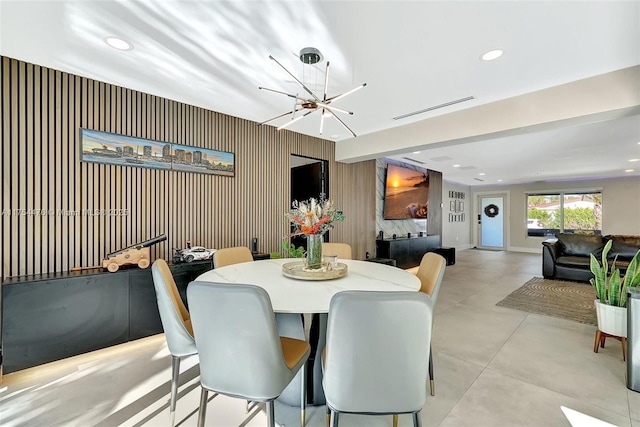 dining room with wallpapered walls, visible vents, concrete floors, a notable chandelier, and recessed lighting