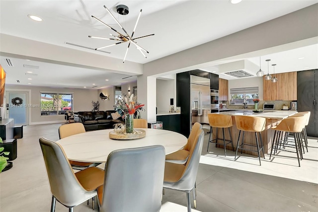 dining space with a notable chandelier, a wealth of natural light, and recessed lighting