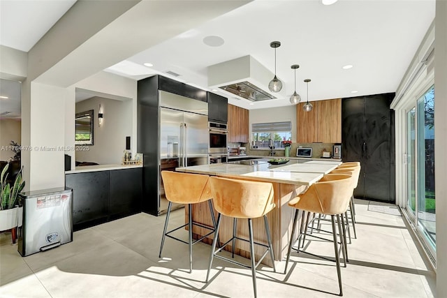 kitchen with a spacious island, modern cabinets, stainless steel appliances, and a kitchen breakfast bar