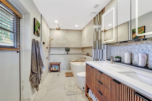 bathroom with tasteful backsplash, a soaking tub, visible vents, a sink, and tile patterned flooring