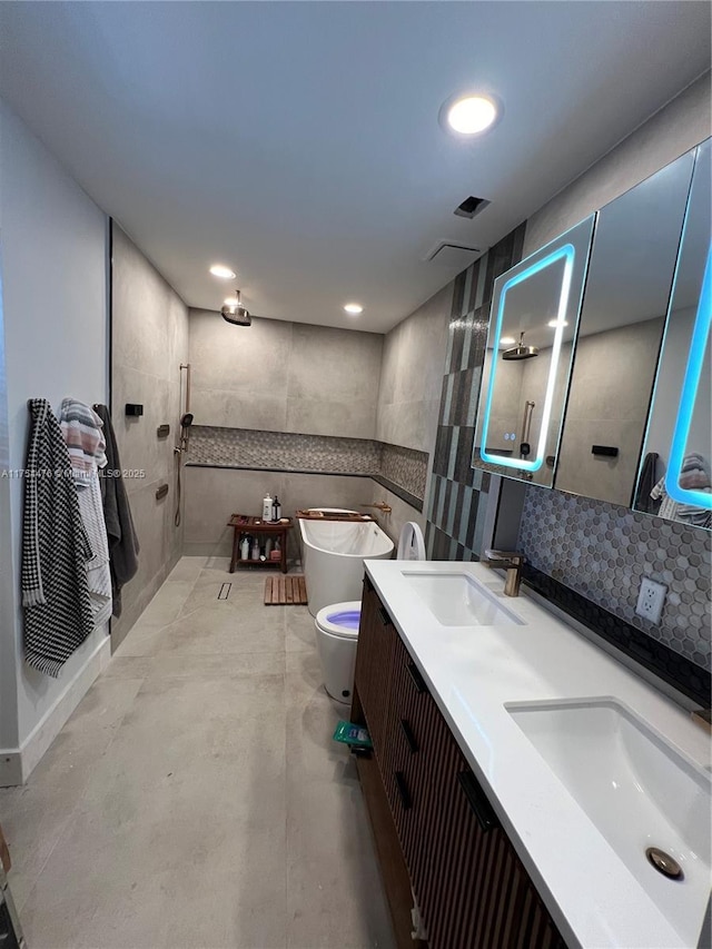 bathroom featuring double vanity, a sink, tile walls, and walk in shower