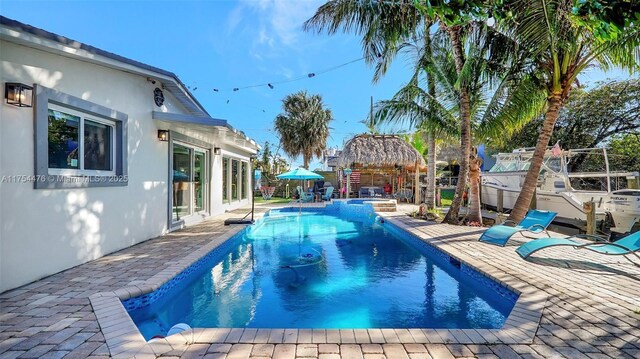 view of swimming pool with a patio area, a pool with connected hot tub, and a gazebo