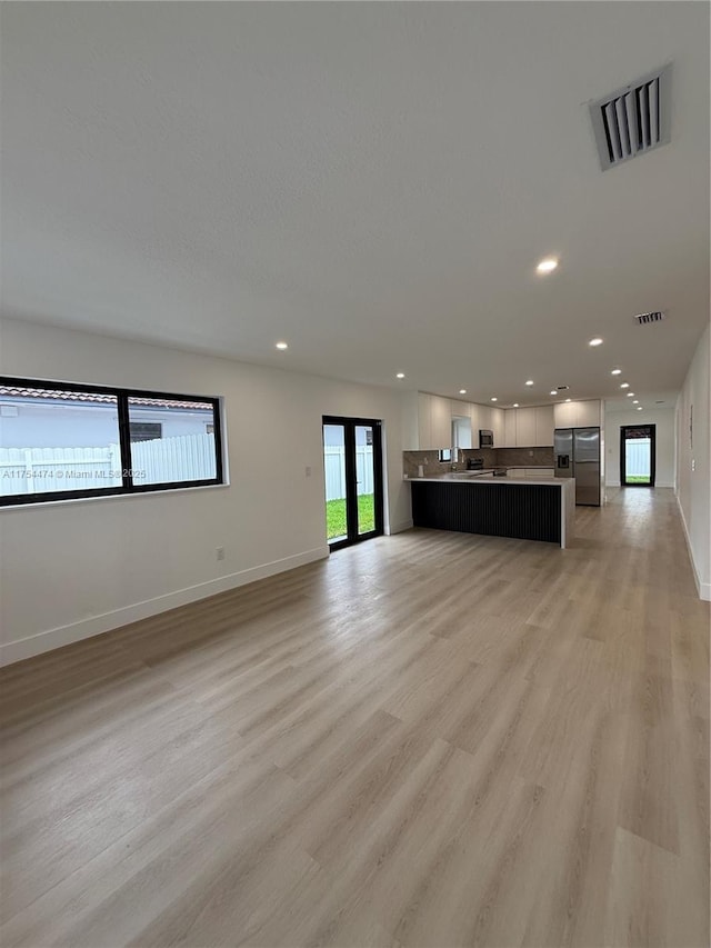 unfurnished living room featuring light wood finished floors, visible vents, and recessed lighting