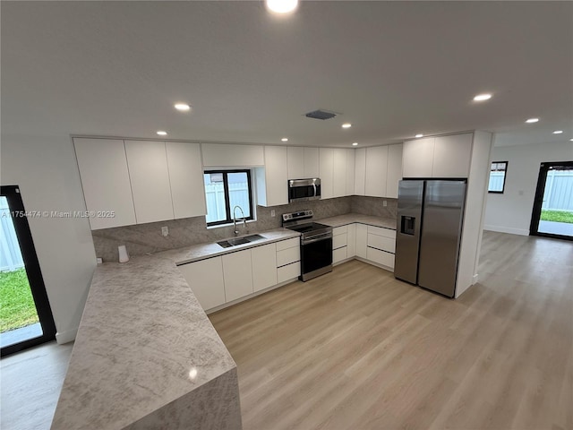 kitchen with stainless steel appliances, modern cabinets, backsplash, and visible vents