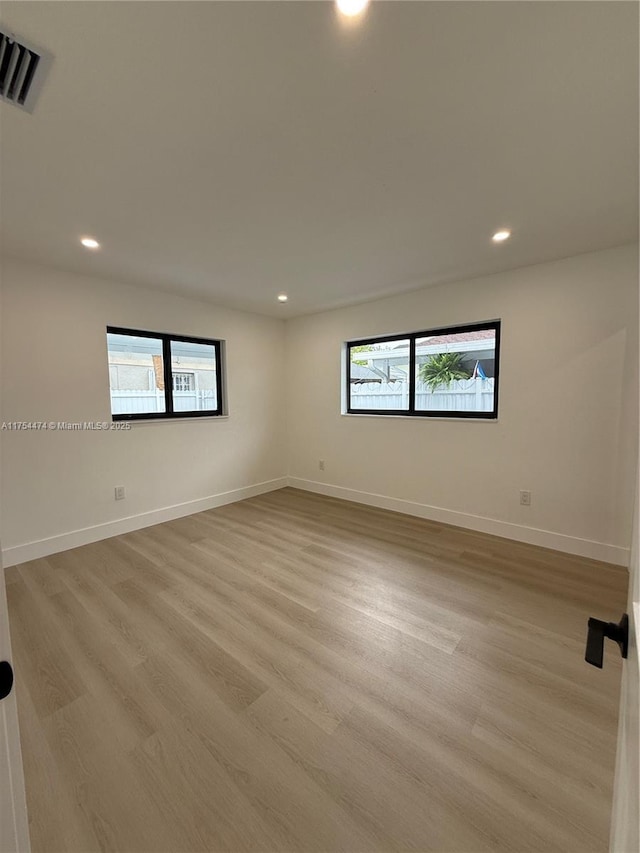 unfurnished room featuring light wood-style flooring, recessed lighting, visible vents, and baseboards