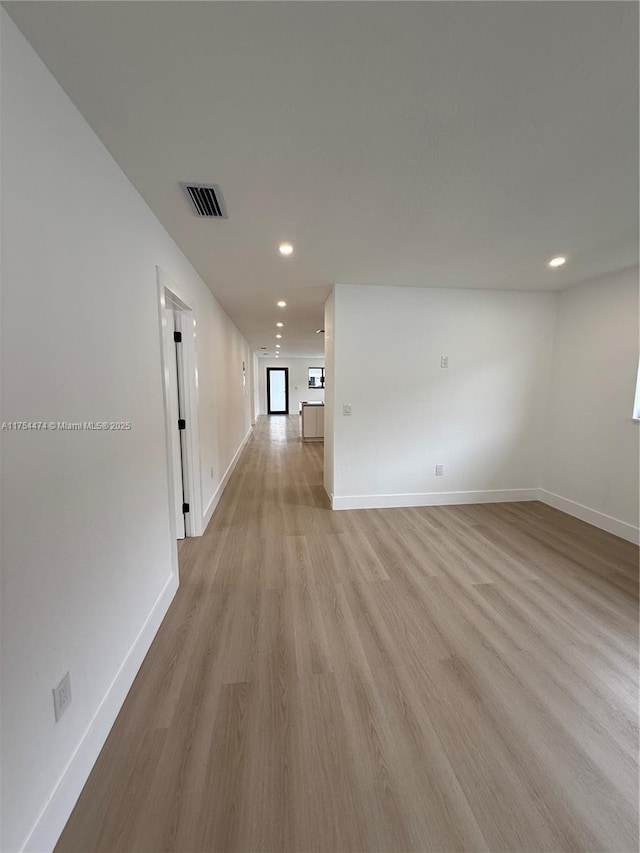 spare room featuring light wood finished floors, baseboards, visible vents, and recessed lighting
