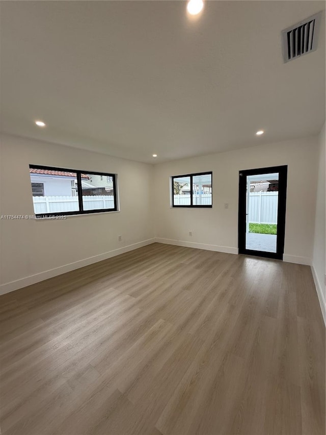 spare room featuring recessed lighting, visible vents, baseboards, and wood finished floors
