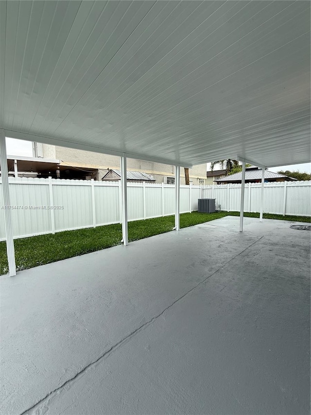 view of patio / terrace with a carport, a fenced backyard, and central AC