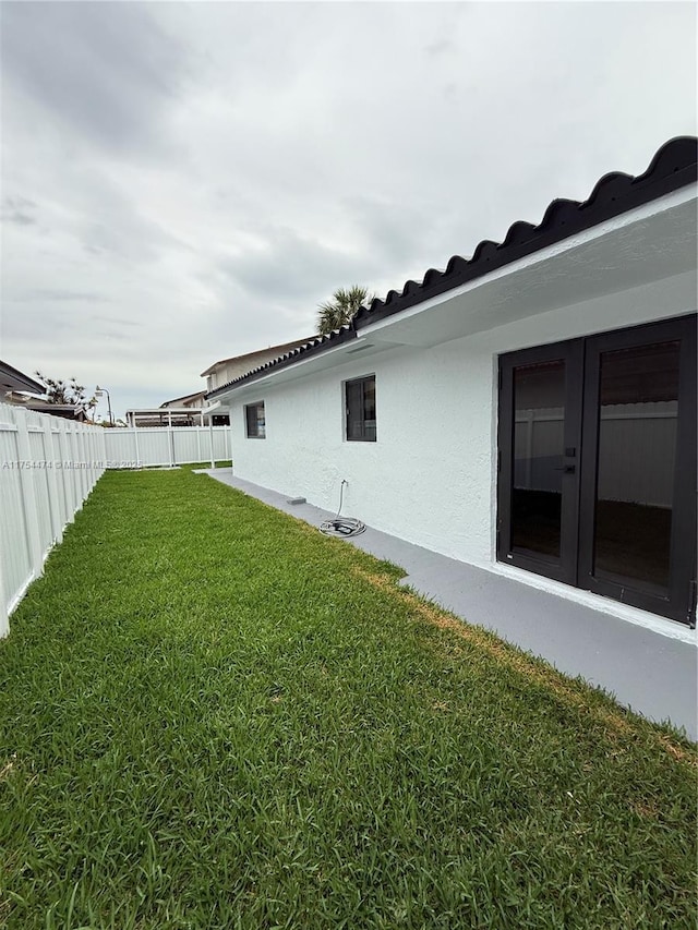 view of home's exterior with a fenced backyard, a lawn, and stucco siding