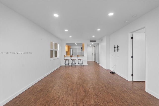 unfurnished living room featuring recessed lighting, visible vents, baseboards, and wood finished floors