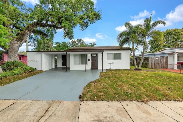 ranch-style home with fence, a front lawn, and stucco siding