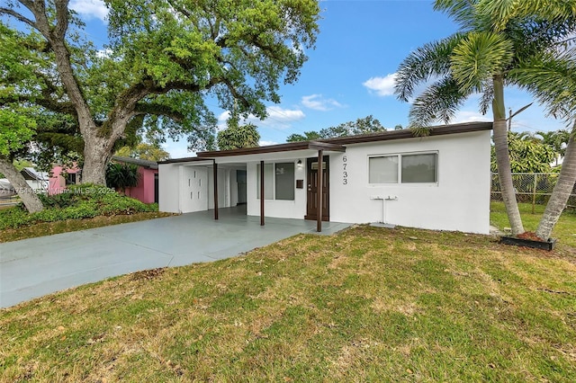 ranch-style home featuring stucco siding, a front yard, and fence