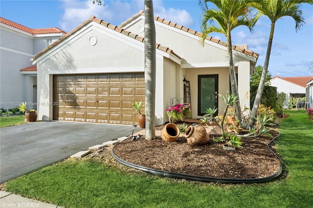 view of front of house with driveway, a tile roof, a garage, and stucco siding