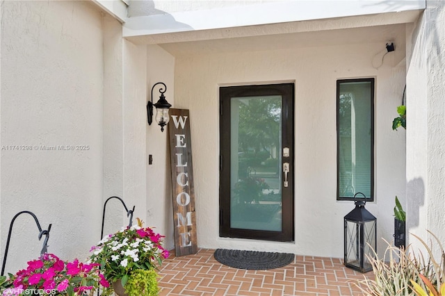 property entrance with stucco siding