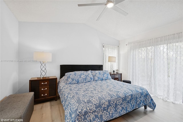 bedroom featuring a textured ceiling, wood finished floors, ceiling fan, and vaulted ceiling