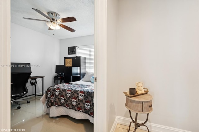 tiled bedroom featuring a textured ceiling, baseboards, and a ceiling fan