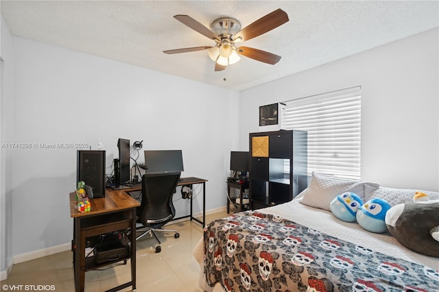 bedroom with ceiling fan, baseboards, and a textured ceiling