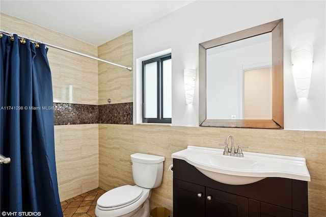 full bath featuring tiled shower, toilet, tile walls, and vanity