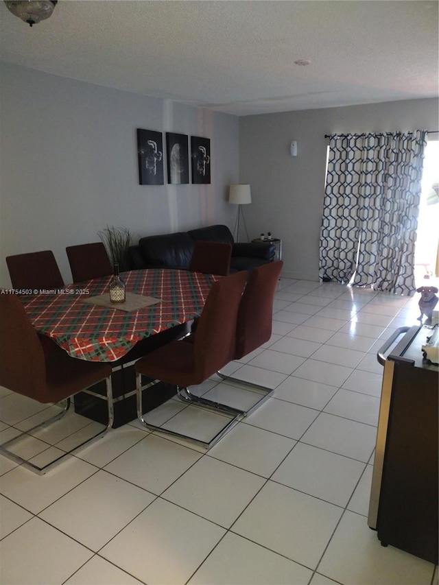 dining room with a textured ceiling and light tile patterned flooring