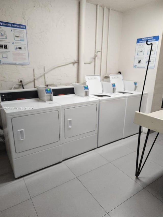 community laundry room featuring separate washer and dryer and light tile patterned flooring