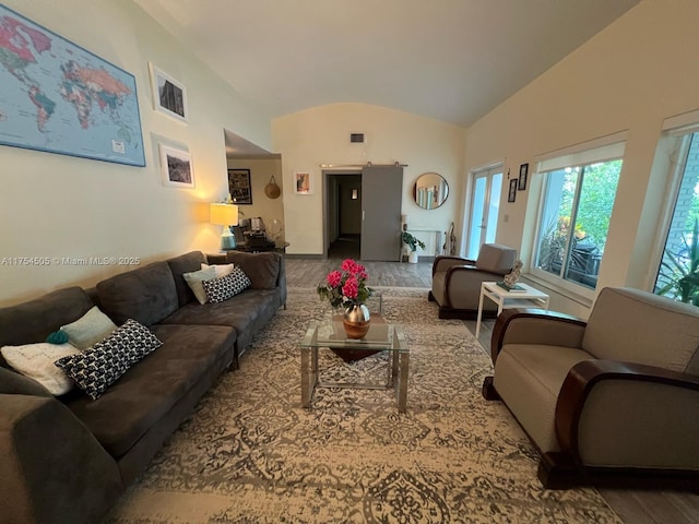 living area with lofted ceiling, a barn door, and visible vents