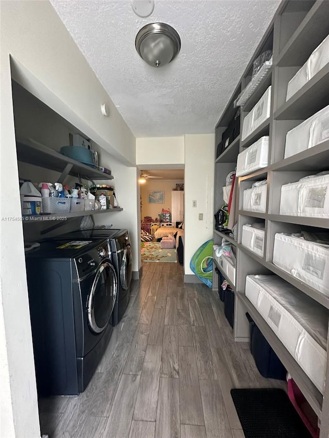 laundry room featuring laundry area, a textured ceiling, dark wood-style flooring, and washing machine and clothes dryer