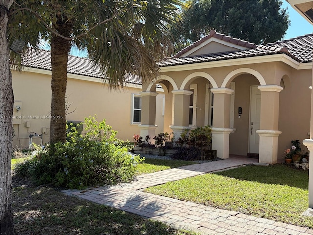 mediterranean / spanish home featuring a tiled roof and stucco siding