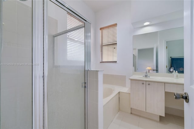 bathroom featuring a stall shower, tile patterned flooring, a garden tub, and vanity