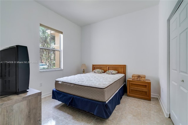 bedroom featuring light tile patterned floors and baseboards