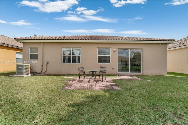 back of property with central air condition unit, stucco siding, a patio, and a yard