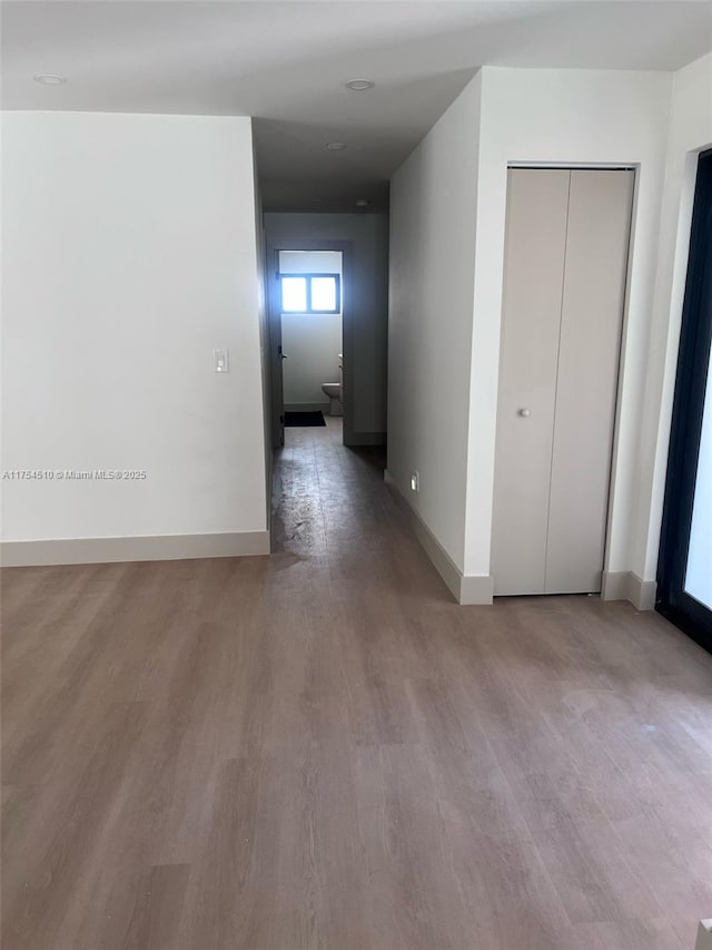 hall featuring baseboards and wood finished floors