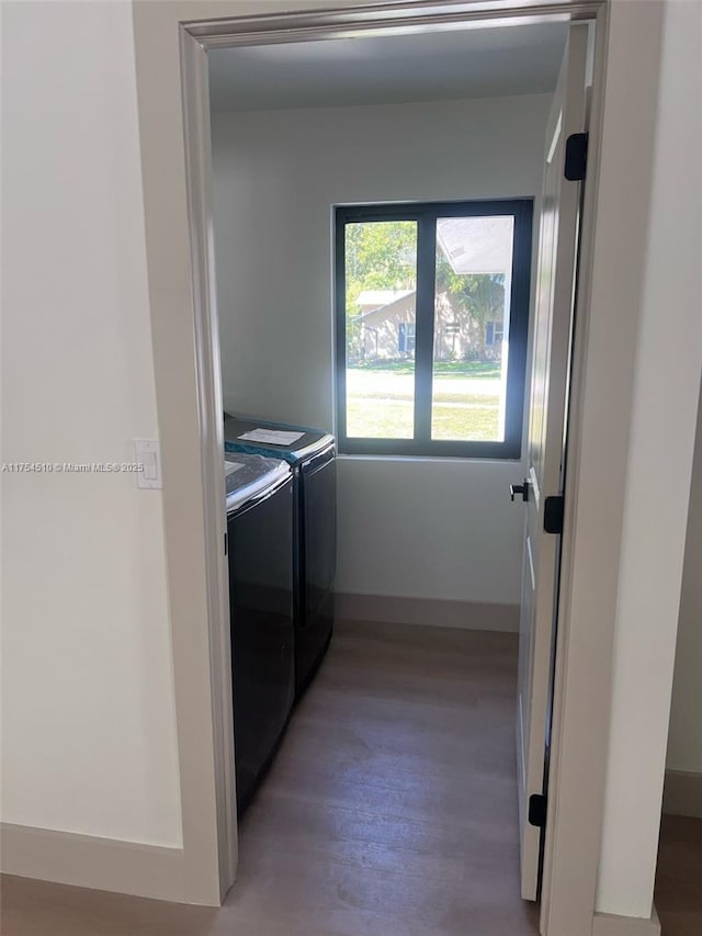 washroom with light wood-type flooring, washer and dryer, laundry area, and baseboards